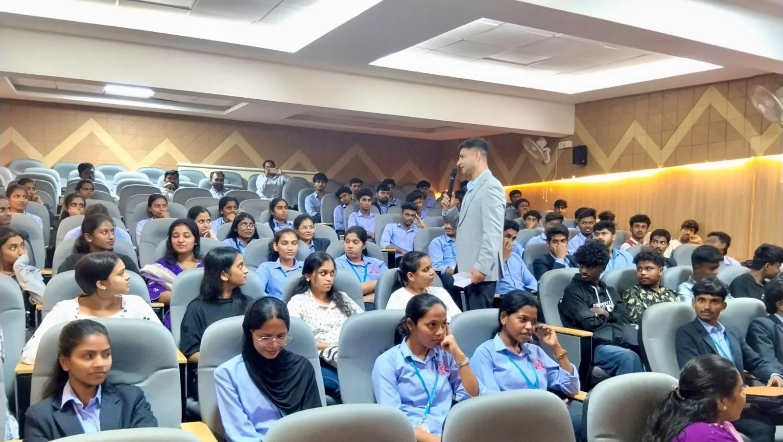 Cdr Naveen Pandita conducting interactive Q&A in the auditorium aisle at MVM College Bengaluru